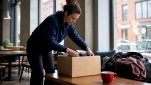 Woman hurriedly packing box in apartment