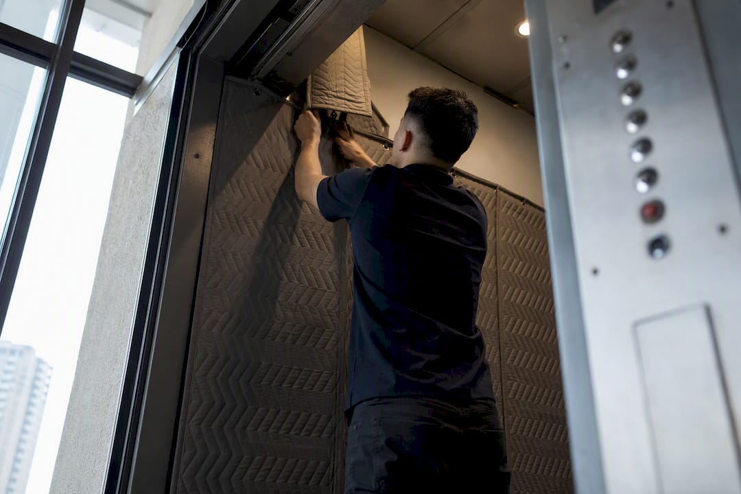 Mover preparing padded freight elevator