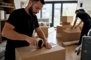 Movers packing boxes inside residential garage