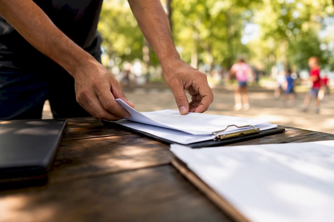 Mover organizing insurance paperwork on clipboard