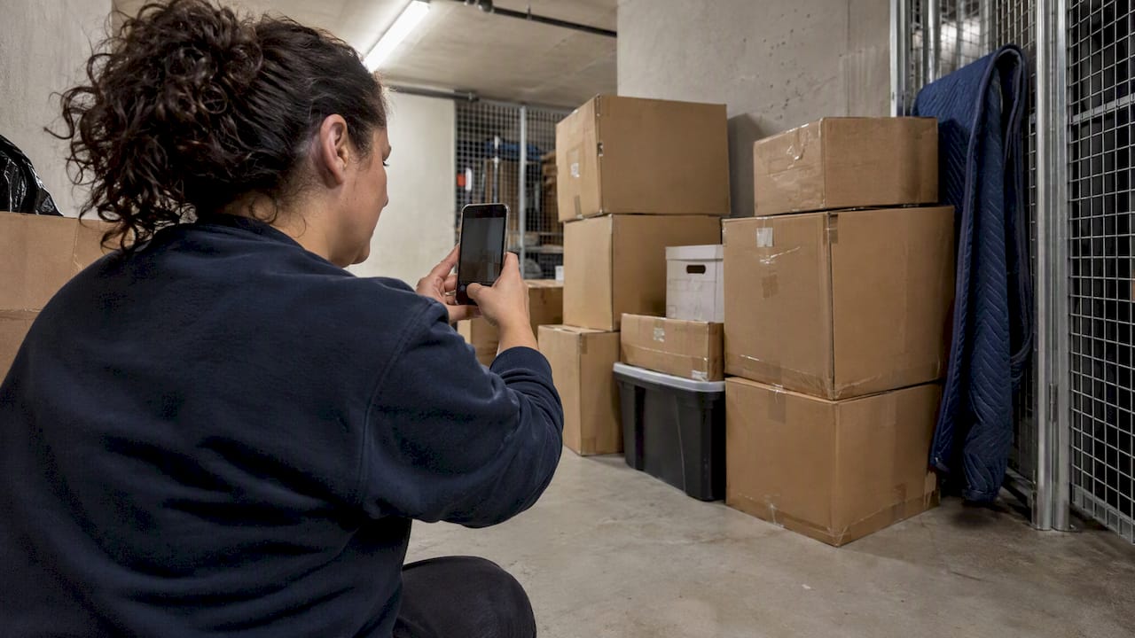 Homeowner photographing packed boxes for inventory